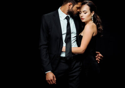 stock-photo-attractive-woman-dress-hugging-handsome-man-isolated-black
